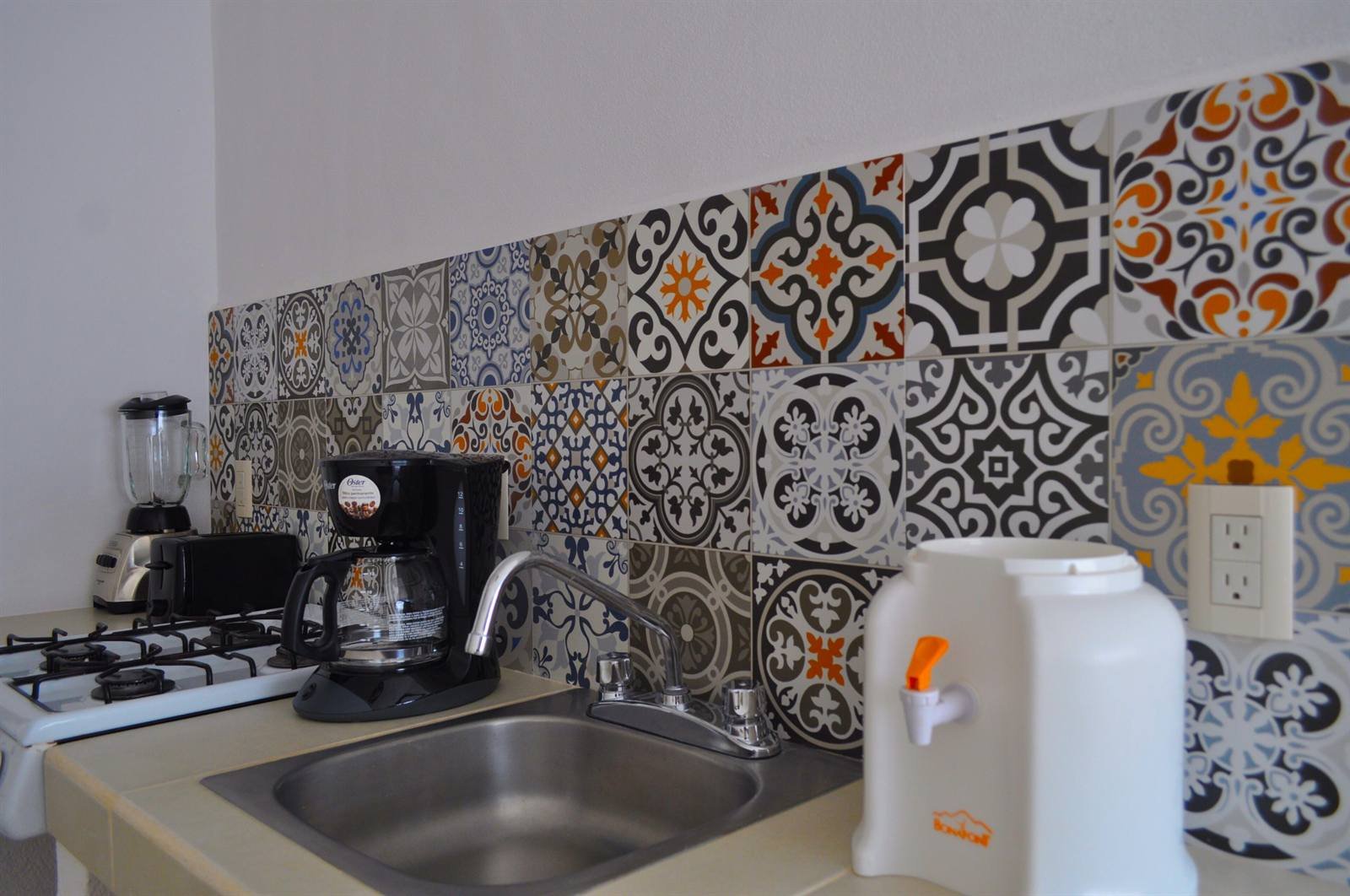 Petit Hotel Pilitas: suite kitchen with Talavera-style tiles, gas stove, coffee maker and water dispenser